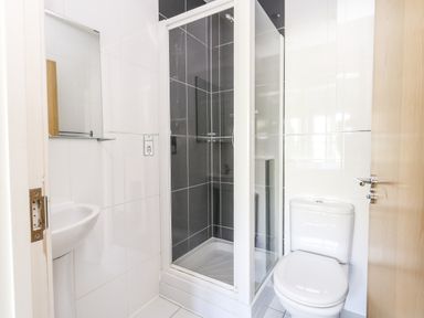 A bathroom with a shower cubicle a toilet and a sink at Marina Reach in Weymouth
