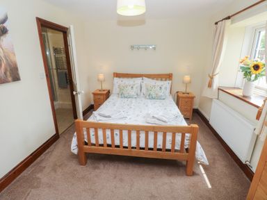 A bedroom with a bed and bedside tables at The Old Dairy in Maenclochog