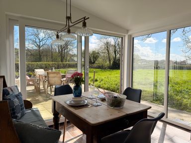 A dining room with a table set for meal at Pensarngerrig in Rhydlewis