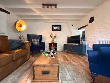 A living room with a sofa and armchairs at Pensarngerrig in Rhydlewis