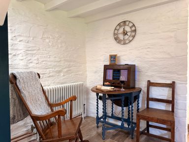 A sitting area with a rocking chair and table at Pensarngerrig in Rhydlewis