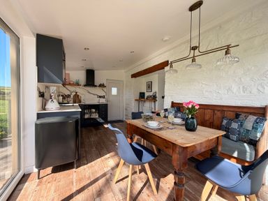 A kitchen with a table and chairs at Pensarngerrig in Rhydlewis