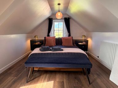 A bedroom with a bed and nightstands at Pensarngerrig in Rhydlewis