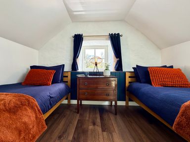A bedroom with two beds and a nightstand at Pensarngerrig in Rhydlewis
