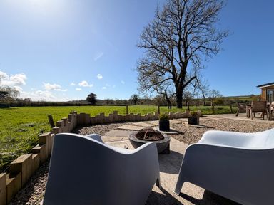 An outdoor area with chairs and a fire pit at Pensarngerrig in Rhydlewis