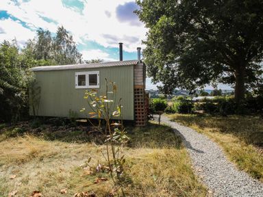 A shepherd hut with a pathway and trees at Aston - Shepherd Hut Aston On Clun