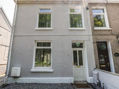 The exterior front view of a two-story house with a white door and three white-framed windows at 5 Pontardulais Road Llangennech