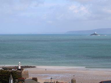 A coastal view with a beach lighthouse and an island lighthouse in the distance at Tredarn in Connor Downs