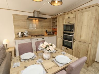 A kitchen with dining table set for four in Crosswinds 68 Bembridge