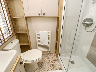 A bathroom with a toilet sink shower and towel rail at Crosswinds 68 in Bembridge