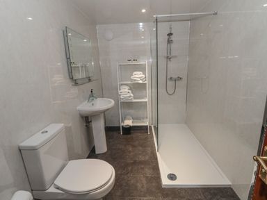 A bathroom with a toilet sink mirror towel rack and a walk in shower at Barnacre Longhirst near Morpeth