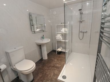 A bathroom with a toilet sink mirror shower and towel rack at Barnacre in Longhirst near Morpeth