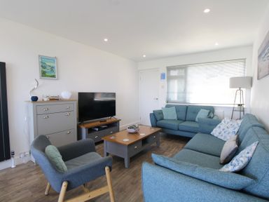 A living room with a sofa and armchair at 65 Channel View in Ilfracombe