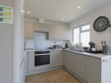 A kitchen with cabinets and appliances at 65 Channel View, Ilfracombe