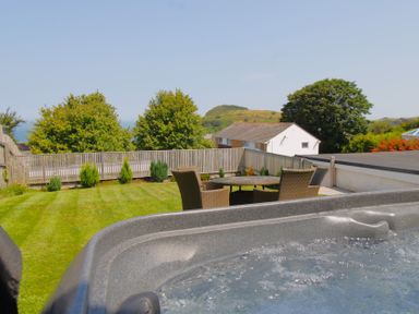 A garden with a hot tub and outdoor seating at 65 Channel View Ilfracombe