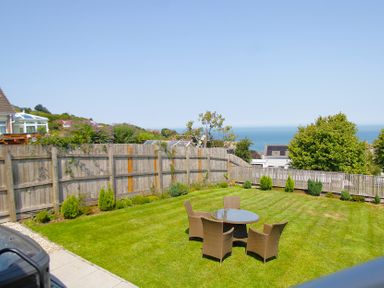 A garden with a table and chairs at 65 Channel View in Ilfracombe