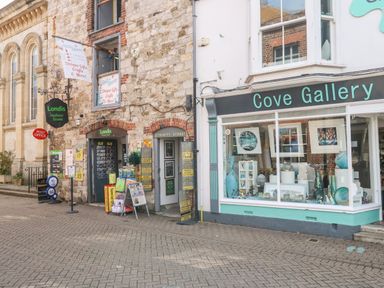 A street view with a Londis store and Cove Gallery shopfront at The Chocolate Box in Weymouth