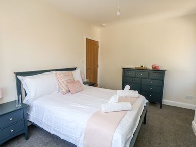A bedroom with a double bed a dresser and bedside tables at The Chocolate Box in Weymouth