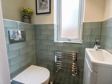 A small bathroom with a toilet sink window and a towel radiator at The Chocolate Box in Weymouth