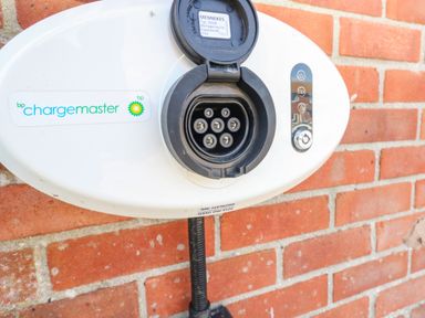 An electric vehicle charging station mounted on a brick wall at Sandpiper in Weymouth