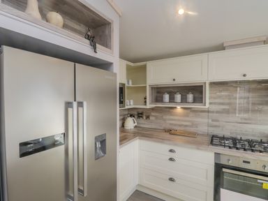 A kitchen with a double door refrigerator stove oven and countertop at No 27 The Crab Pot Runswick Bay near Staithes