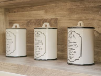 Three labeled kitchen canisters for tea coffee and sugar on a wooden shelf at No 27 The Crab Pot Runswick Bay near Staithes