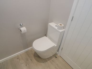 A bathroom with a toilet and toilet paper on the holder and tank at No 27 The Crab Pot Runswick Bay near Staithes