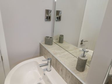 A bathroom sink with a soap dispenser and toothbrush holder on the countertop at No 27 The Crab Pot in Runswick Bay near Staithes