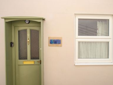 A green door with the number nine and a window with curtains at Blanche Cottage in Brewers Quay Harbour