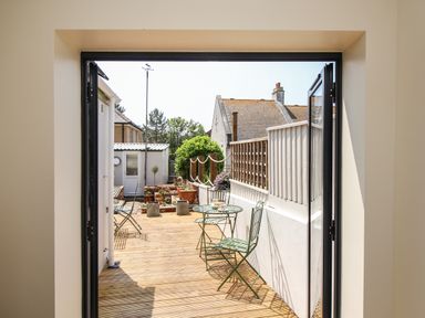 A small outdoor patio with green metal table and chairs and potted plants at Blanche Cottage Brewers Quay Harbour