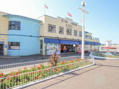 The pier bandstand building with union flags and flower beds outside at Pam's House in Weymouth