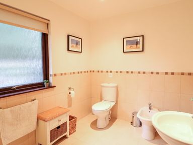 A bathroom with a toilet bidet sink towel rack and window at Ptarmigan Lodge in Glengoulandie near Aberfeldy