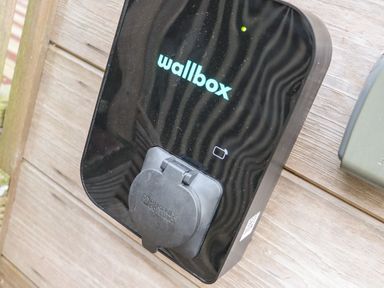 A wall mounted electric vehicle charging station on a wooden exterior wall at Tolcarne in Porthtowan