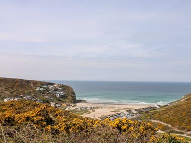 A coastal village with houses near a sandy beach and ocean at Tolcarne Porthtowan