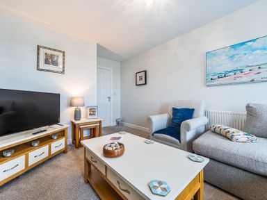 A living room with a television and a coffee table at Solway View Skinburness near Silloth