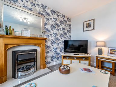 A living room with a fireplace and television at Solway View in Skinburness near Silloth