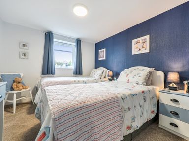 A bedroom with two beds and a teddy bear at Solway View in Skinburness near Silloth