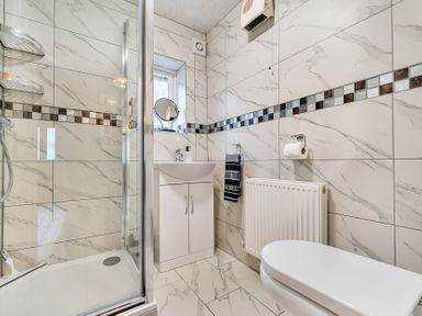 A bathroom with a shower, sink, and toilet at Solway View in Skinburness near Silloth