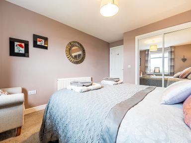 A bedroom with a bed and decorative items at Solway View in Skinburness near Silloth