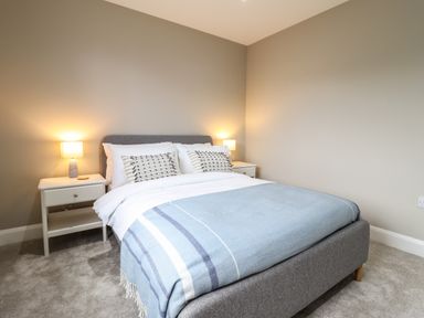 A bedroom with a double bed and bedside tables with lamps at Bryn Hafod in Dyffryn Ardudwy