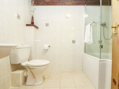 A bathroom with a toilet a sink a bathtub with glass panel and shower at Wheal Prosper@The West Dry in St Austell