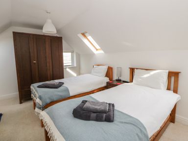 A bedroom with two beds and a wardrobe at Awen Ingli Newport, Pembrokeshire
