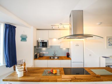A kitchen with wooden countertops a stove and food on the counter at Broadleys Swanage