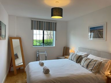 A bedroom with a bed and mirror at Broadleys in Swanage