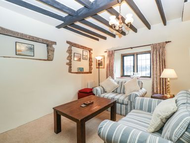 A sitting room with striped sofas a wooden coffee table and exposed ceiling beams at Red Roof Marsh near Combe St Nicholas
