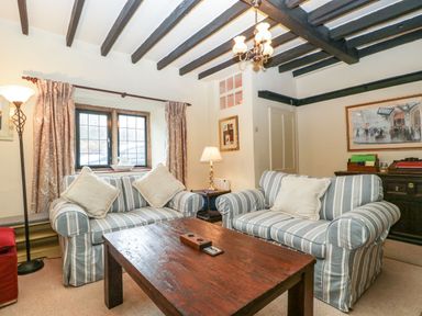 A living room with two striped sofas and a wooden coffee table at Red Roof Marsh near Combe St Nicholas
