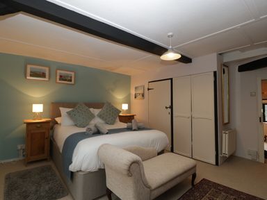 A bedroom with a double bed two bedside tables with lamps and a chaise lounge at Red Roof Marsh near Combe St Nicholas