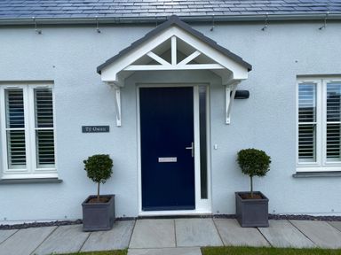A front door with two potted plants on either side at Ty Owen in Newport Pembrokeshire
