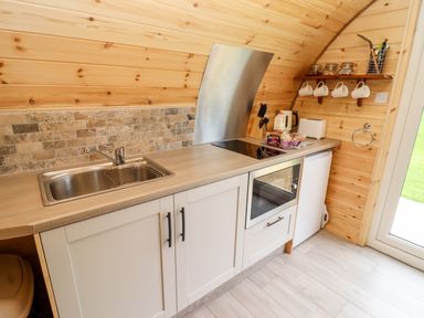 A kitchen area with a sink stove oven and countertop appliances at Meadow Lodge @ Berrys Place Farm in Churcham