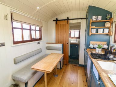 A kitchen with seating space and cabinets at Sweet Caroline Shepherd’s Hut Low Marnham near Sutton-On-Trent